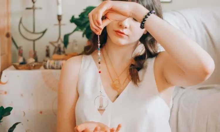 ragazza con in mano un pendolo