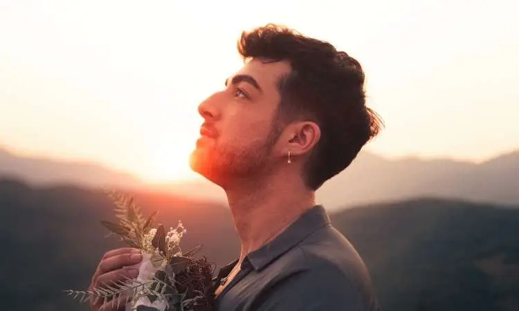 ragazzo guarda verso il cielo al tramonto