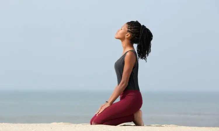 donna pratica pranayama su una spiaggia