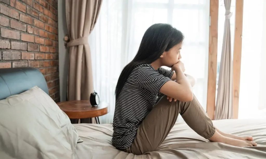 ragazza pensierosa seduta sul letto