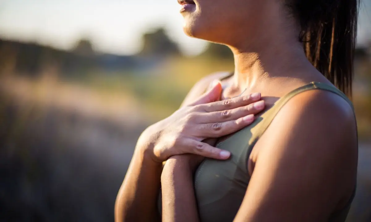 donna respira tenendosi le mani sul petto