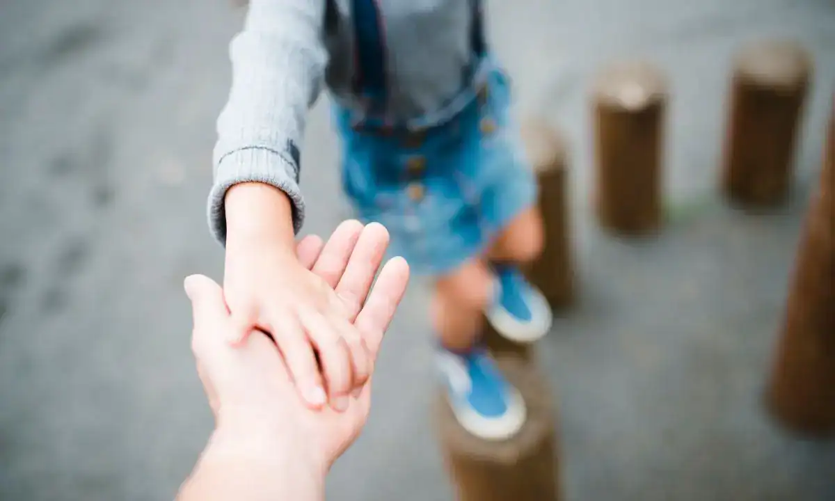 bambino tende la mano verso il genitore