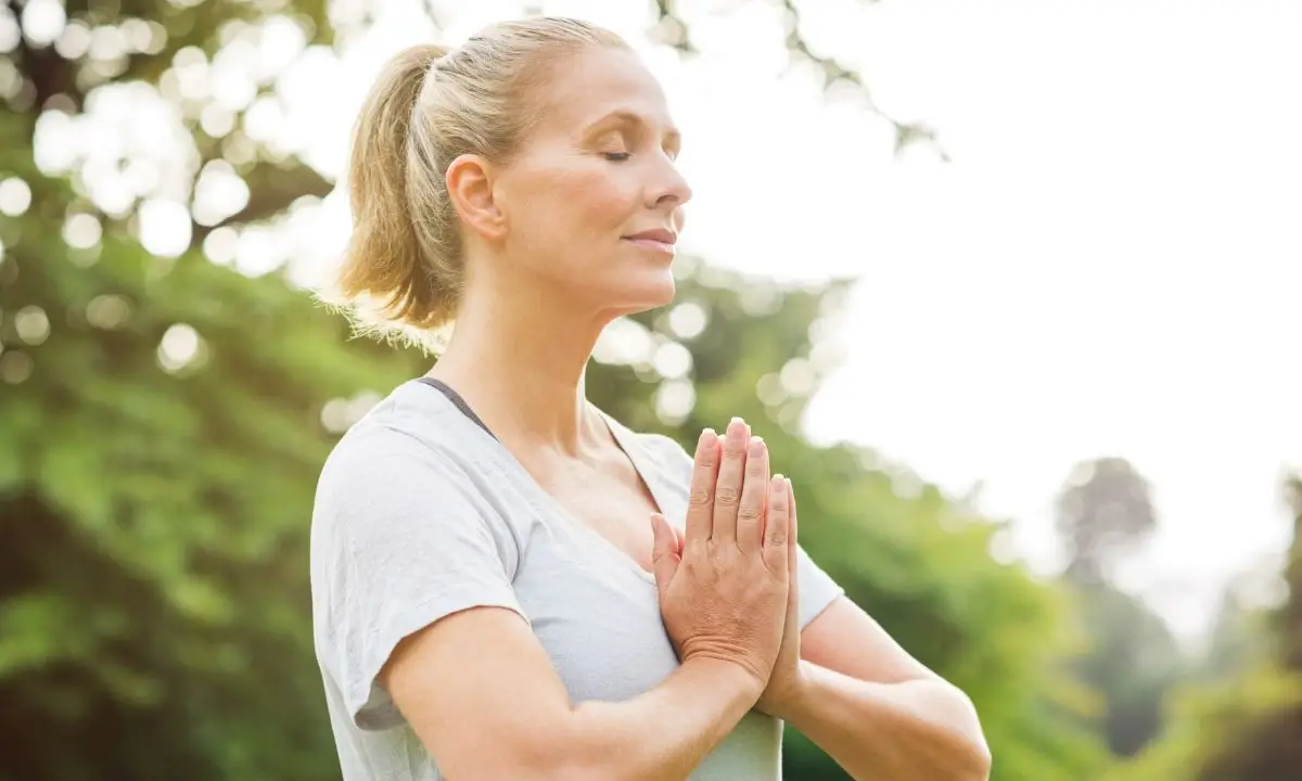 donna sorride mentre medita