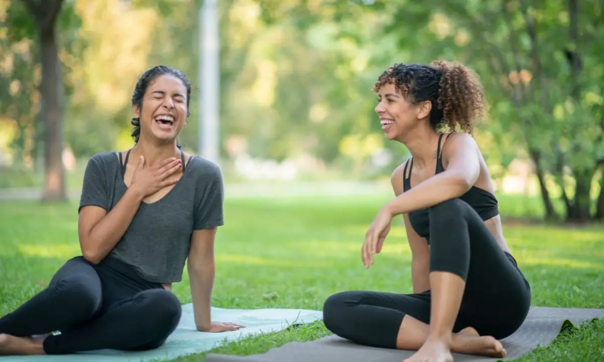 donna ride spontaneamente seduta su un tappetino da yoga