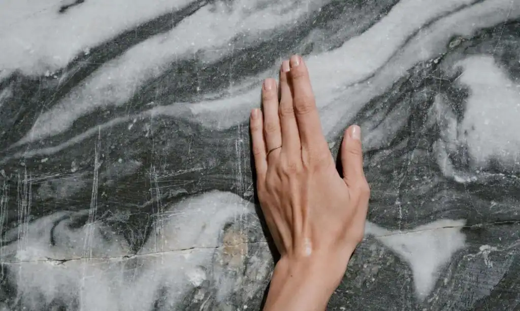 primo piano di una mano su una parete di roccia