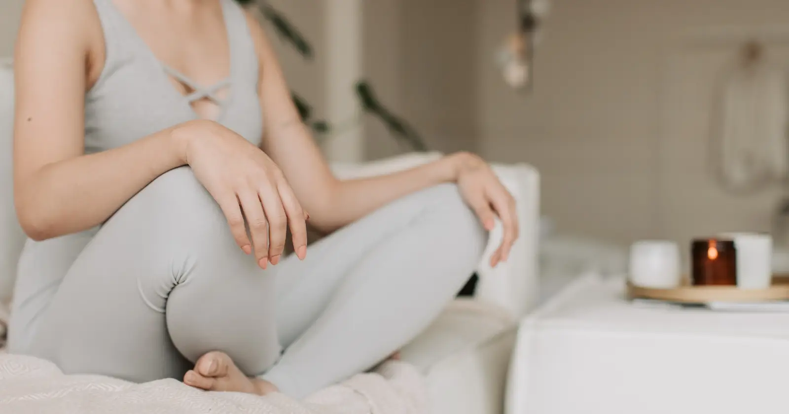 donna medita a gambe incrociate seduta sul letto