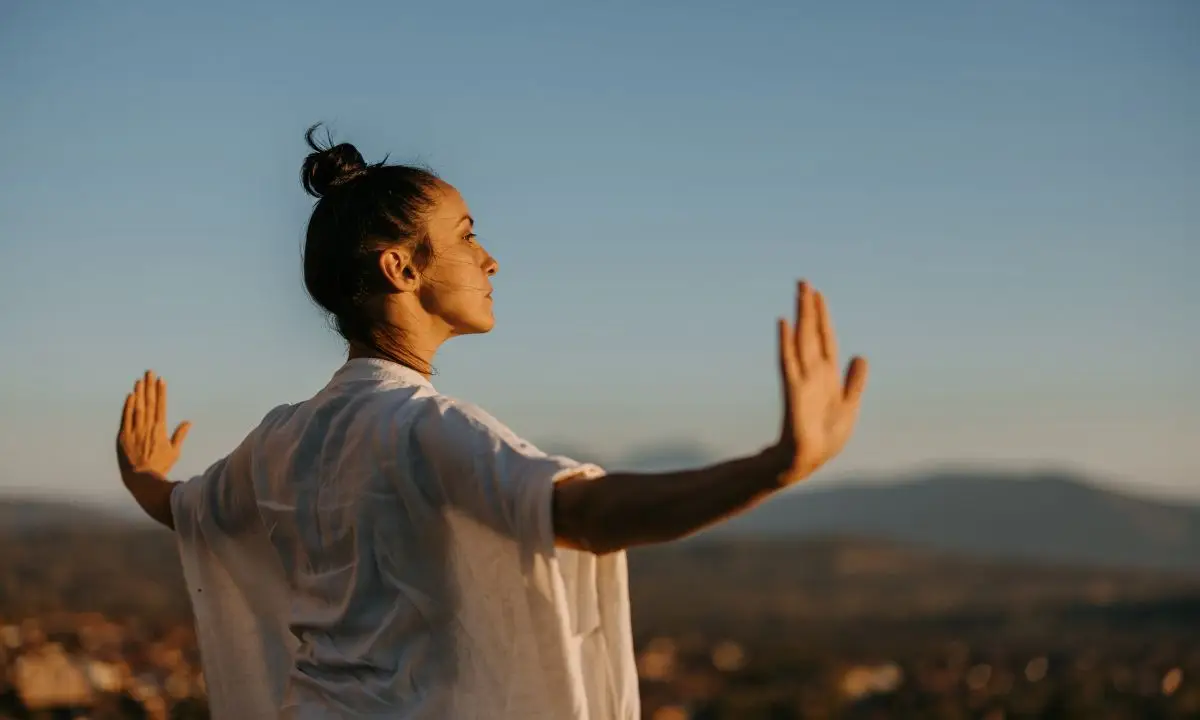 donna a braccia aperte respira guardando il cielo