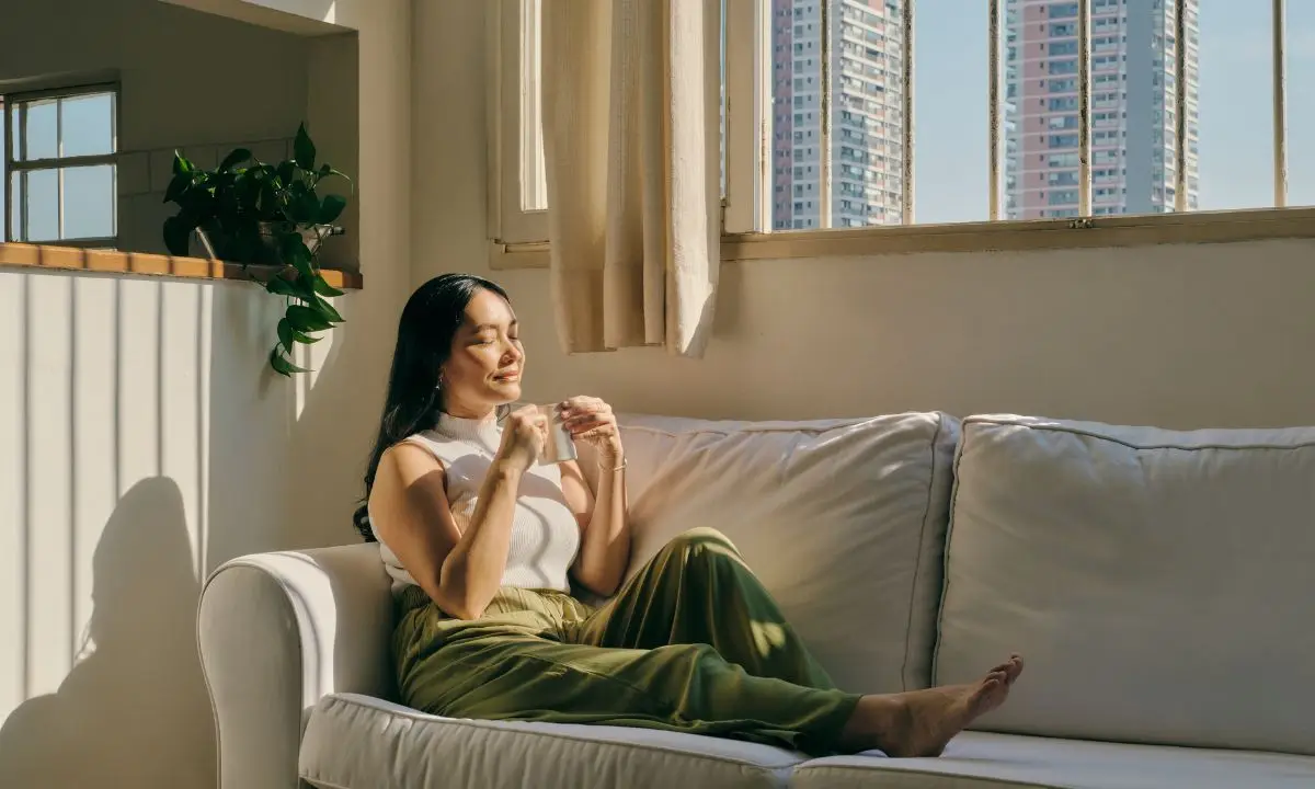 donna si gode un tè seduta sul divano