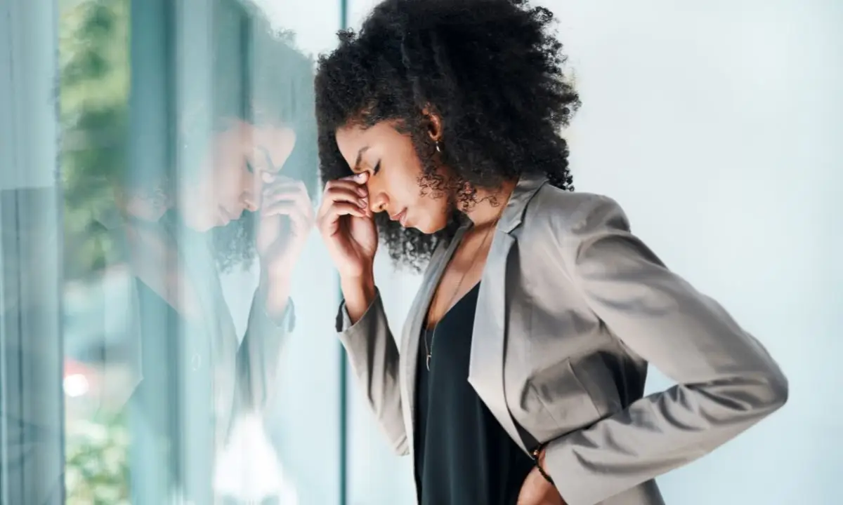 donna si tiene la testa tra le dita, stanca