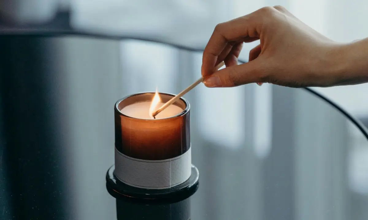 mano femminile accende una candela