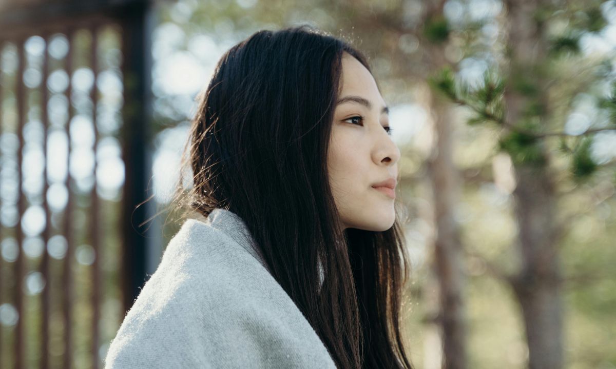 primo piano di una donna pensierosa nella natura