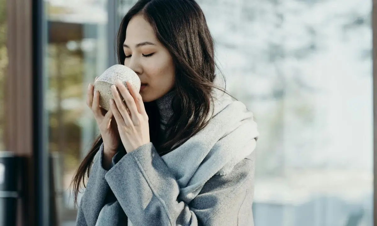 donna sorseggia una tazza di tè